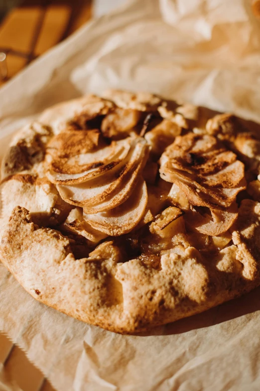 a pizza sitting on top of a wooden table, inspired by Géza Dósa, unsplash, renaissance, apple pie, petals, pear, caramel. rugged