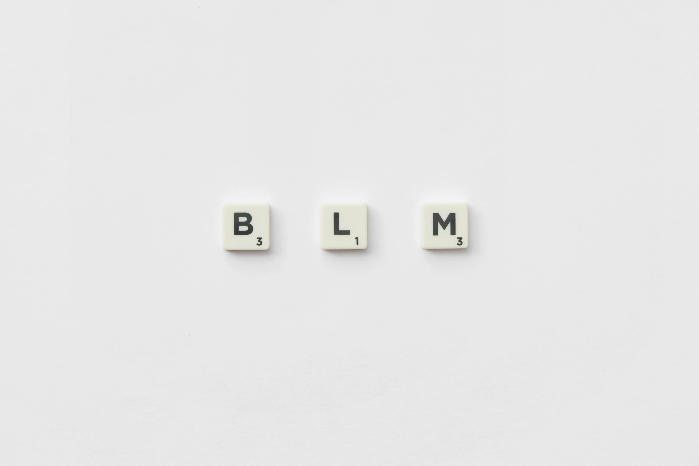 the word blm spelled in scrabbles on a white surface, by Vija Celmins, letterism, large medium and small elements, style of the game rimworld, | 35mm|, glaze