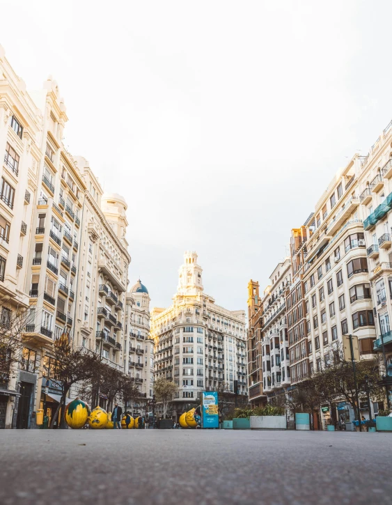 a city street filled with lots of tall buildings, by Hirosada II, unsplash contest winner, art nouveau, plaza, spanish, low quality photo, deserted