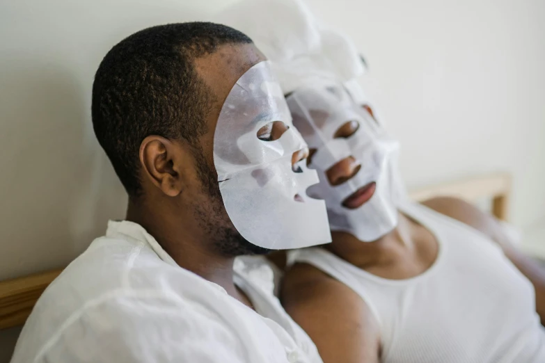 a man and woman laying in bed with masks on their faces, african facial features, taejune kim, profile image, candy treatments