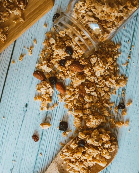 a wooden spoon filled with granola next to a jar of granola, by Alice Mason, trending on pexels, renaissance, square, 🍸🍋, blue, banner