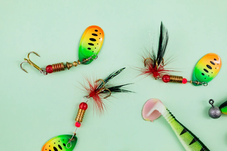 a variety of fishing lures laid out on a green surface, by Julia Pishtar, sundown misty firefly wisps, 3 colours, kami, thumbnail