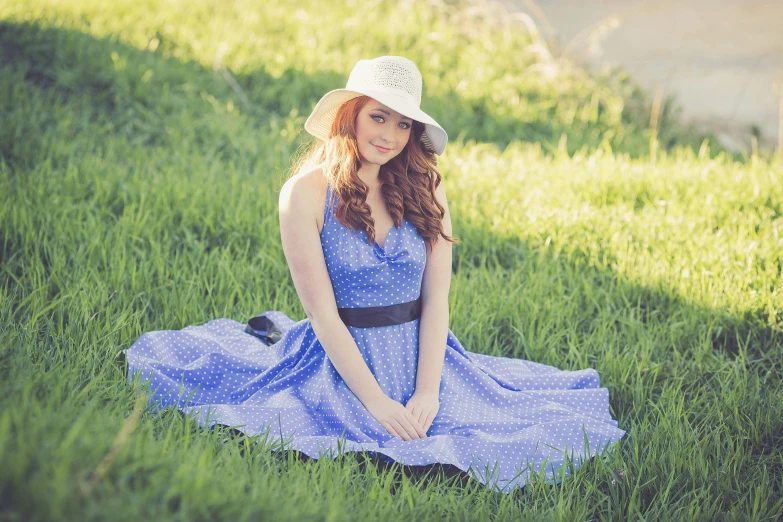 a woman sitting on top of a lush green field, a portrait, flickr, blue checkerboard dress, blue fedora, ( redhead, square