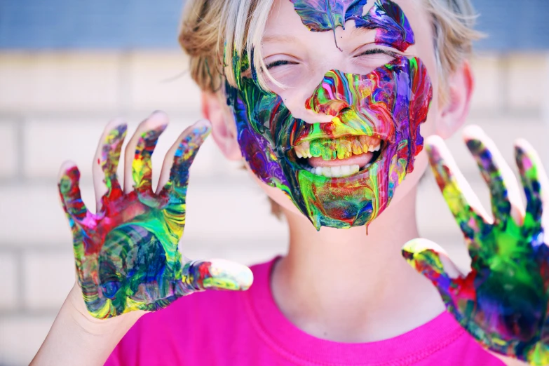 a girl with paint all over her face and hands, pexels, teen boy, brightly coloured, mischievous expression, with colourful intricate