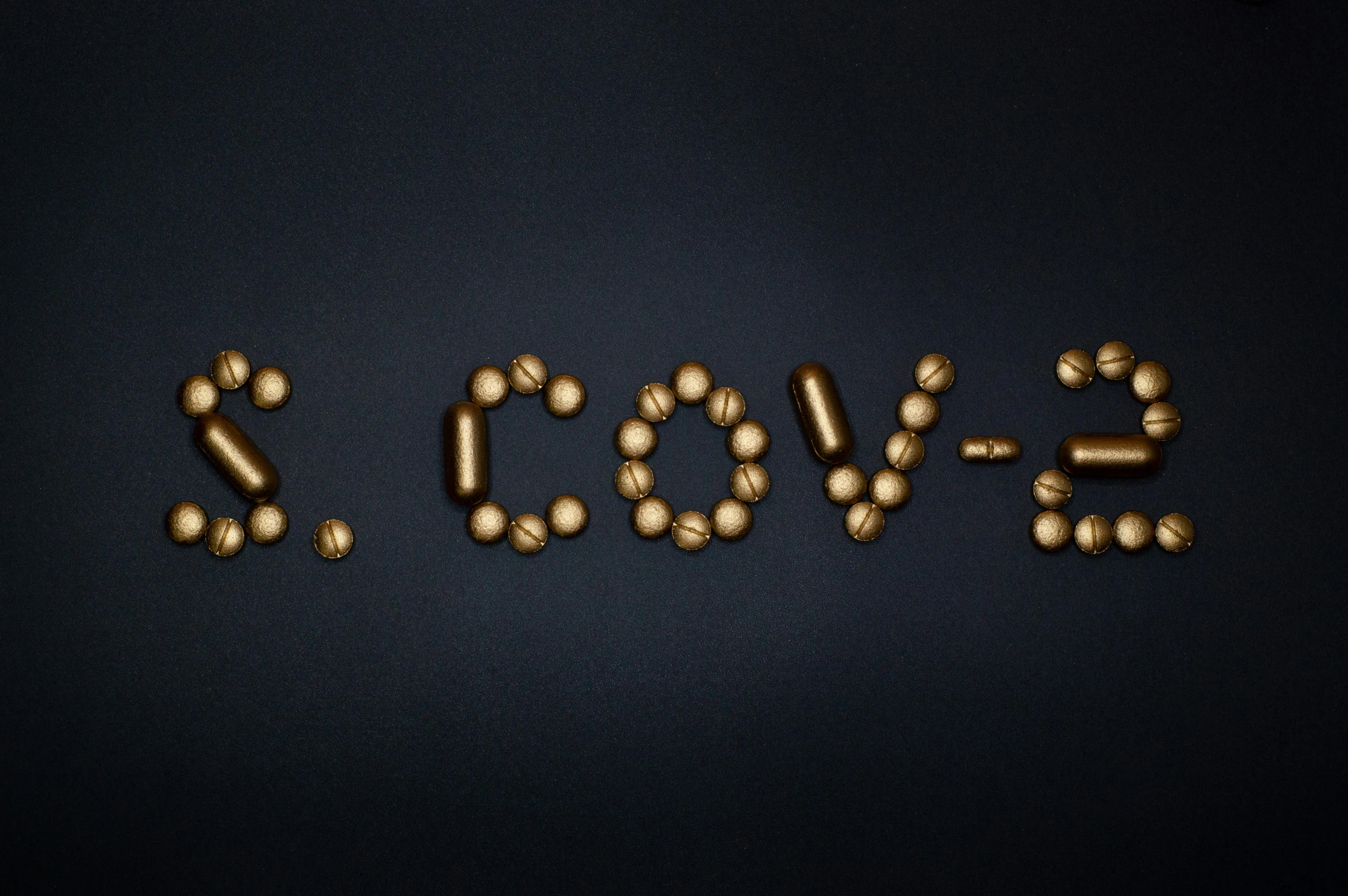 the word love spelled out of pills on a black background, an album cover, by Bascove, bronze!! (eos 5ds r, cute coronavirus creatures, cowl, golden orbs