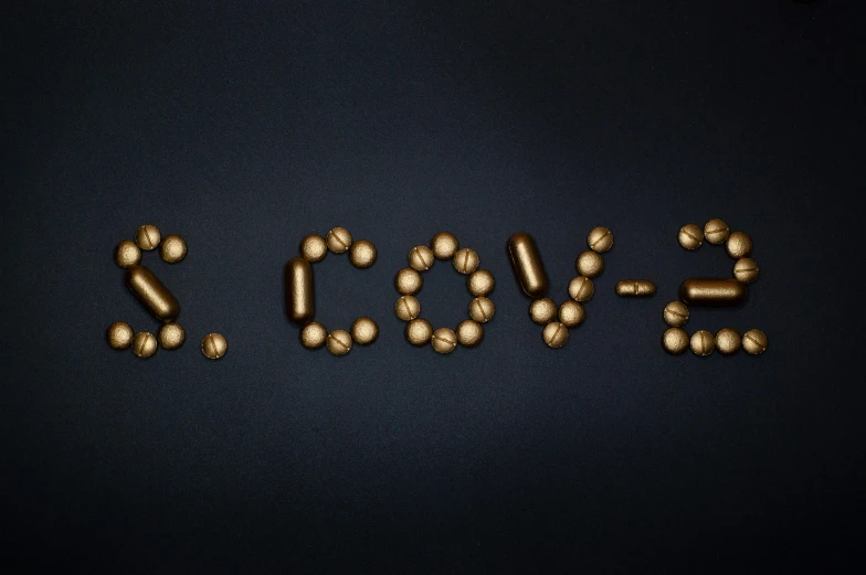 the word love spelled out of pills on a black background, an album cover, by Bascove, bronze!! (eos 5ds r, cute coronavirus creatures, cowl, golden orbs