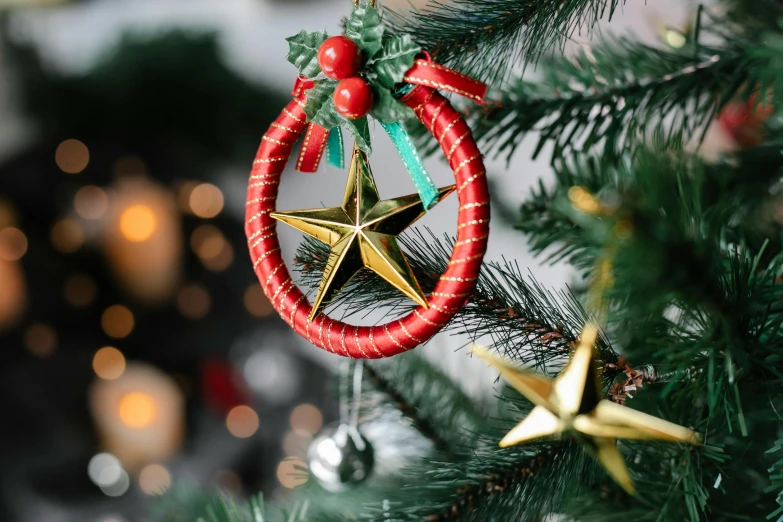 a christmas ornament hanging from a christmas tree, by Julia Pishtar, pexels, hurufiyya, dreamcatchers, star, ornamental halo, red and golden color details