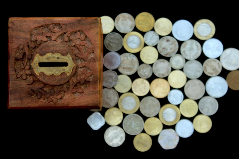 a wooden box sitting on top of a pile of coins, by Jessie Algie, pexels contest winner, arte povera, islamic art, medieval coin texture, coloured, 1970'