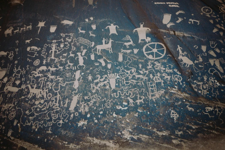 a close up of a painting on a wall, a cave painting, by Jessie Algie, trending on unsplash, shamanistic dark blue clothes, chalkboard, moab, on a gray background