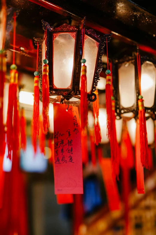 a bunch of red and white lanterns hanging from a ceiling, inspired by Cui Bai, trending on pexels, colorful signs, in a temple, soft red lights, an old