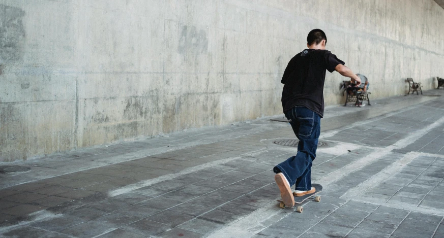 a man riding a skateboard down a sidewalk, unsplash contest winner, wearing a dark shirt and jeans, aged 13, carving, 15081959 21121991 01012000 4k