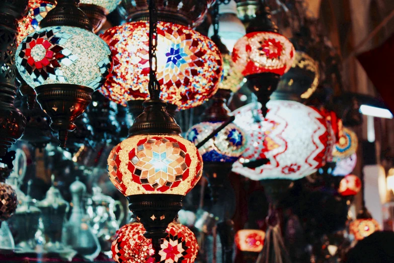 a bunch of different colored lamps hanging from a ceiling, a mosaic, trending on unsplash, arabesque, red lanterns, sparkly, photographed on colour film, instagram post