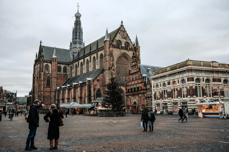 a group of people standing in front of a church, by Jan Tengnagel, pexels contest winner, baroque, square, holiday season, brown, delft