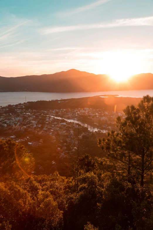 the sun is setting over a large body of water, by Jakob Gauermann, happening, hills and ocean, golden hour 8 k, sun and shadow over a city, manuka