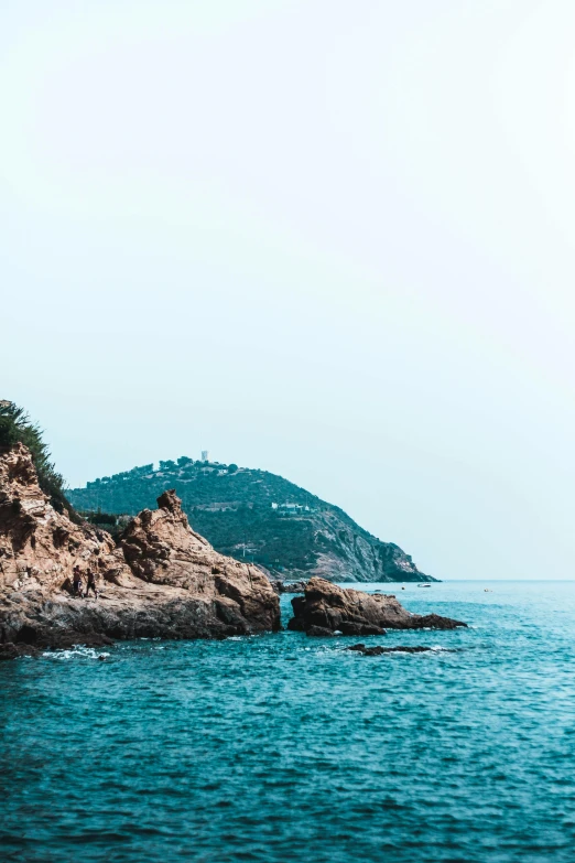 a large body of water next to a rocky shore, a picture, inspired by Elsa Bleda, trending on unsplash, renaissance, mediterranean fisher village, 2 5 6 x 2 5 6 pixels, hillside, slide show