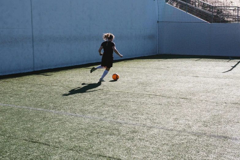 a person kicking a soccer ball on a field, on the concrete ground, private school, in spain, let's play