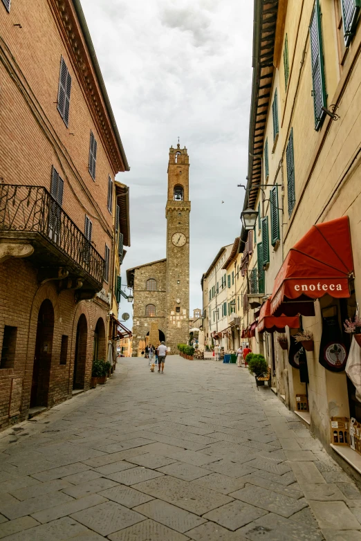 a narrow street with a clock tower in the background, renaissance, running through italian town, lots of shops, well preserved, in the center of the image