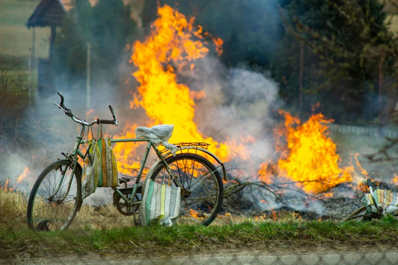 a bike that is sitting in front of a fire, by Jesper Knudsen, green gas spreading across land, full frame image, festivals, multiple stories