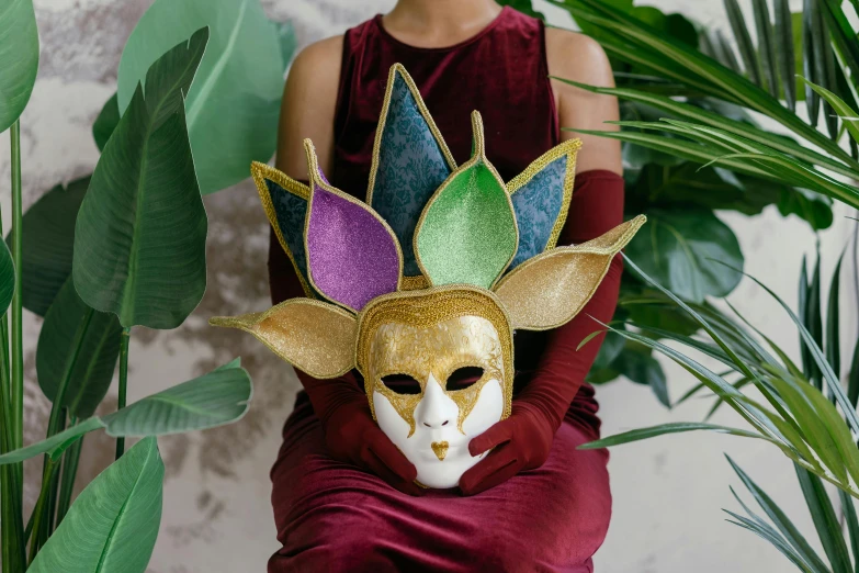 a woman in a red dress holding a mask, trending on pexels, renaissance, alien colorful greenery, wearing a light grey crown, iridescent and golden, iridescent venetian blown glass