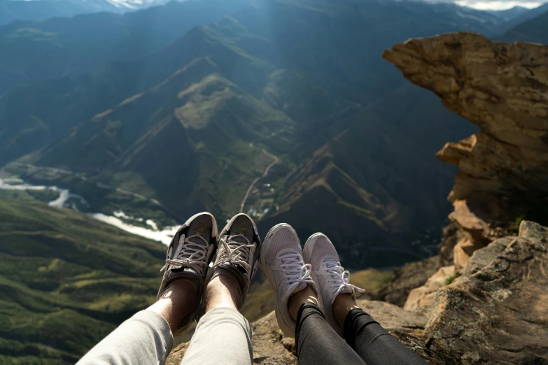 a couple of people sitting on top of a mountain, pexels contest winner, realism, sneakers, peru, detailed shot legs-up, georgic