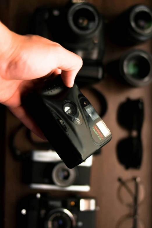 a close up of a person holding a camera, tech noir, vapor, full product shot, panorama shot