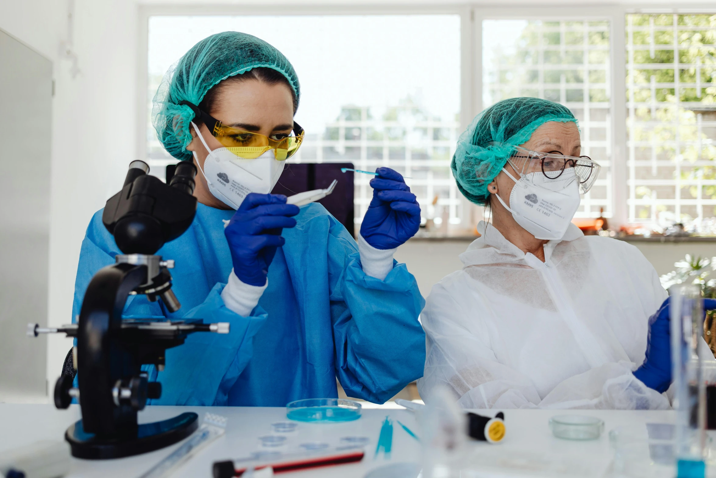 a couple of women standing next to each other in a lab, a portrait, by Adam Marczyński, shutterstock, surgical supplies, plating, wearing goggles, youtube thumbnail