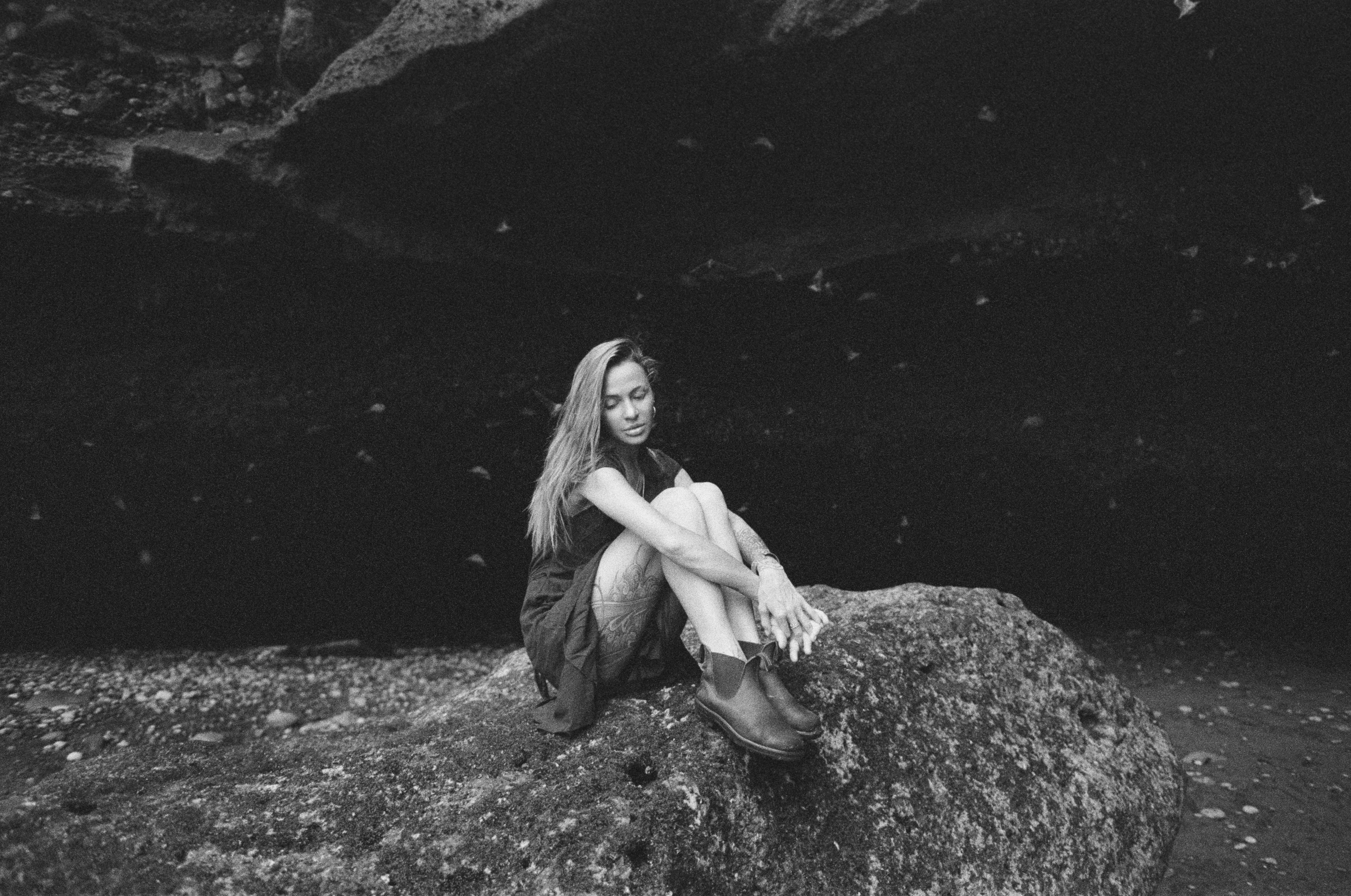 a black and white photo of a woman sitting on a rock, a black and white photo, unsplash, barefoot beautiful girl alien, young blonde woman, analog film, ekaterina