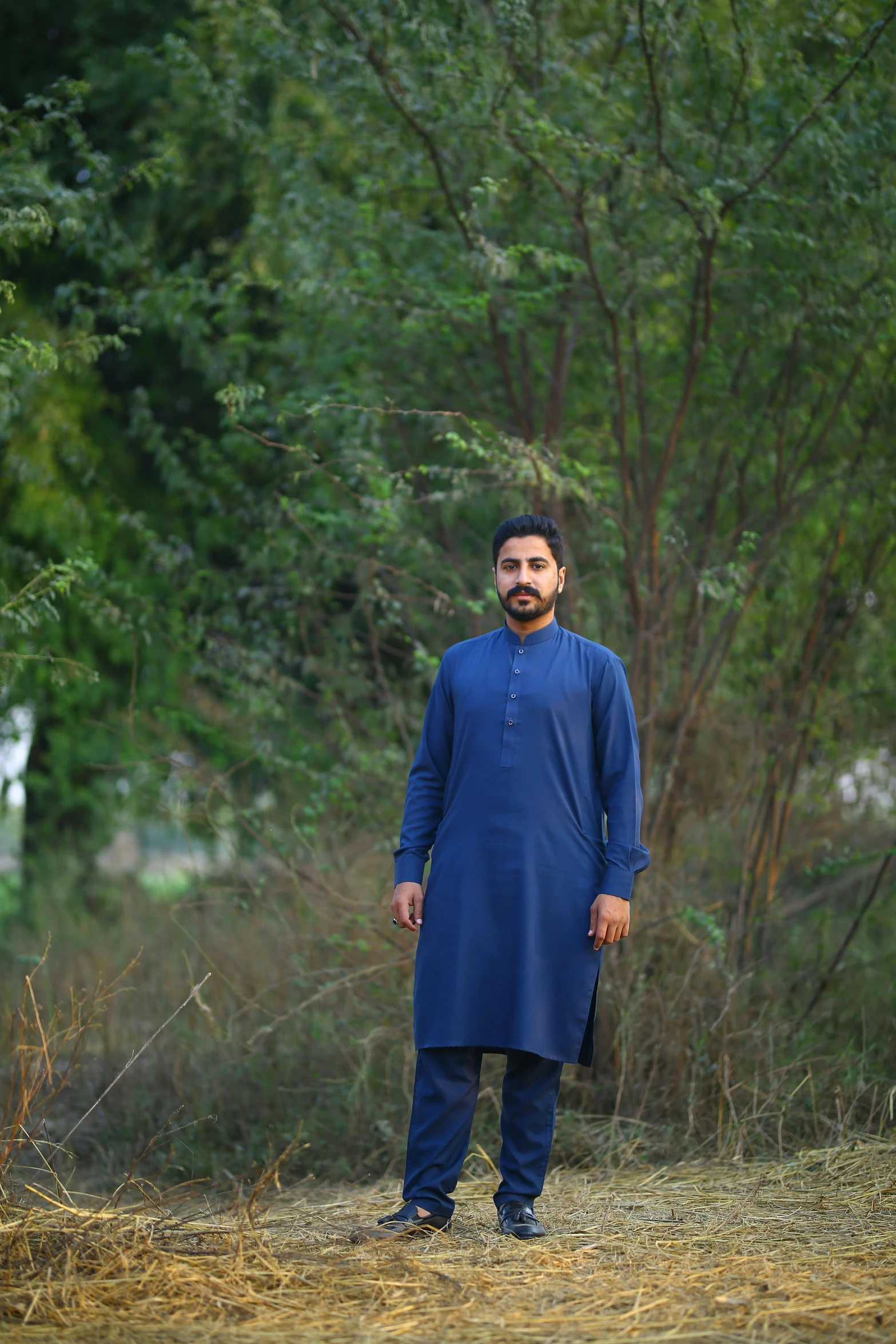 a man standing next to a cow in a field, an album cover, by Riza Abbasi, pexels, dressed in blue, in garden, wearing a kurta, (night)