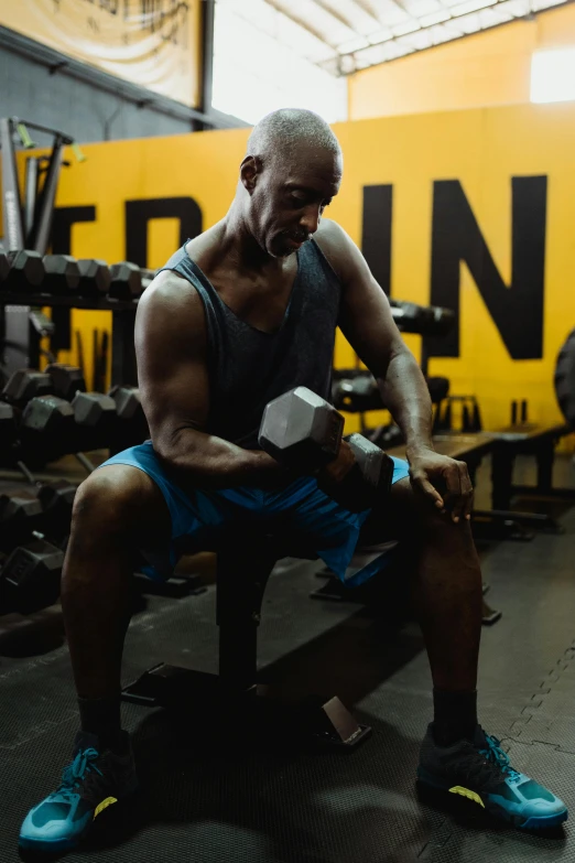 a man sitting on a bench in a gym, by Terrell James, pexels contest winner, figuration libre, holding a hammer, kevin garnett, square, thumbnail