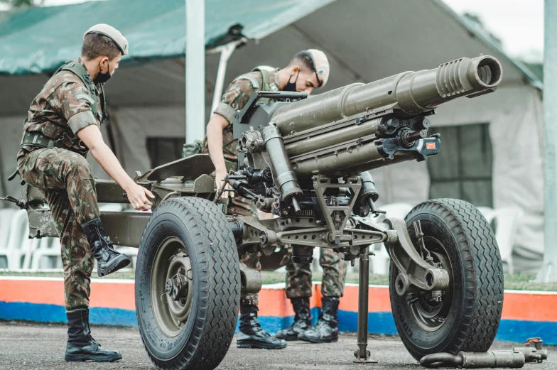 a couple of men standing next to a cannon, by Adam Marczyński, shutterstock, hurufiyya, special forces security, são paulo, pokemon military drill, himars with missile