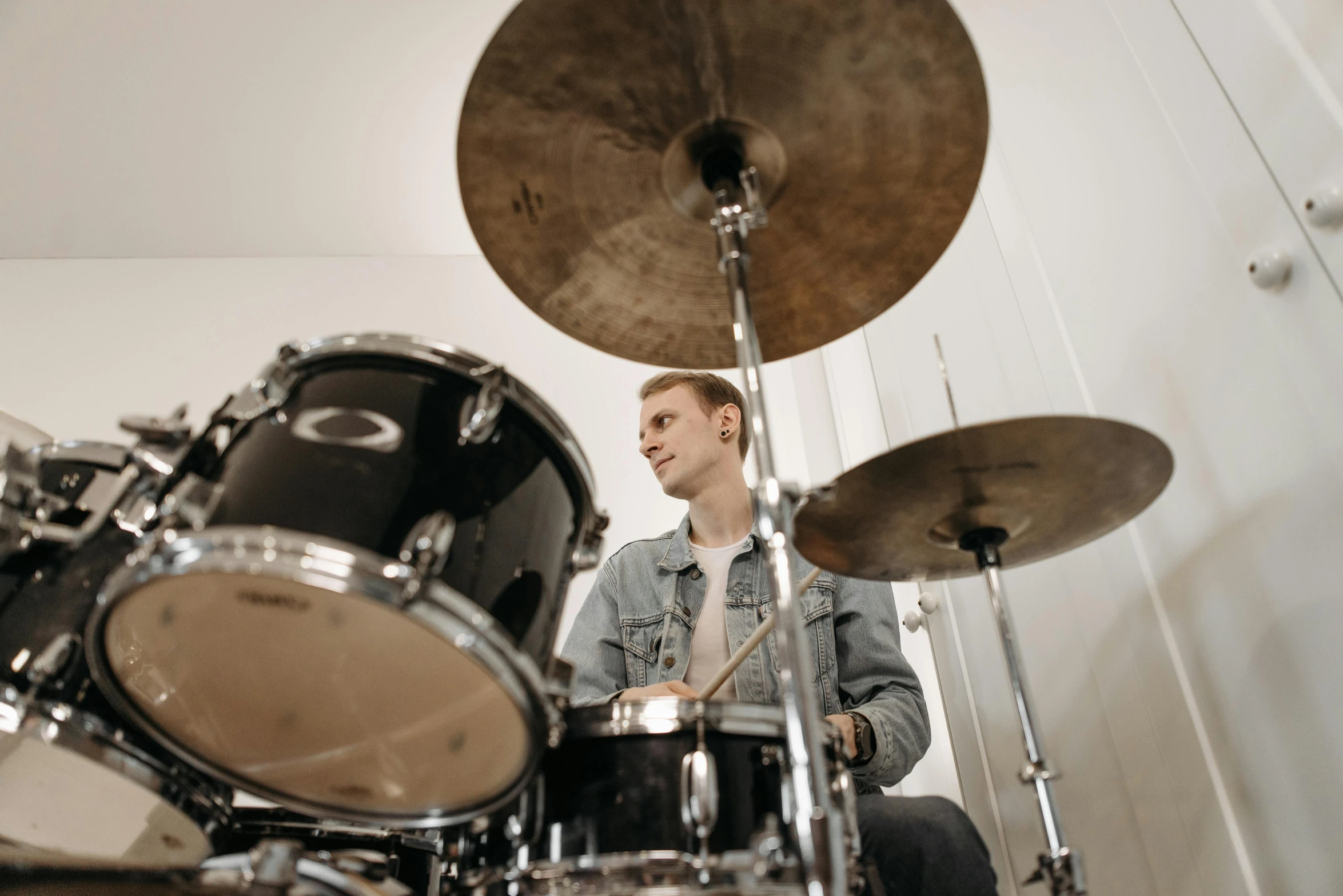 a man sitting in front of a drum kit, pexels contest winner, profile image, a blond, middle centered, acoustic information