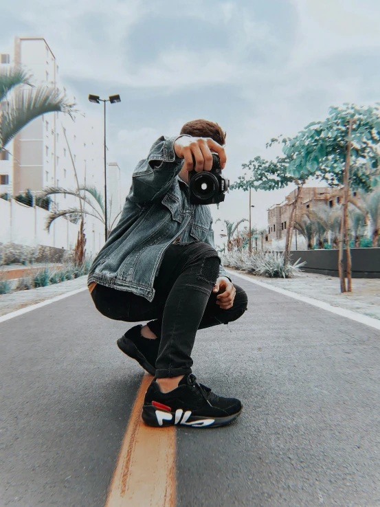 a man riding a skateboard down the middle of a street, unsplash contest winner, wearing adidas clothing, holding a dslr camera, sitting on the ground, profile image