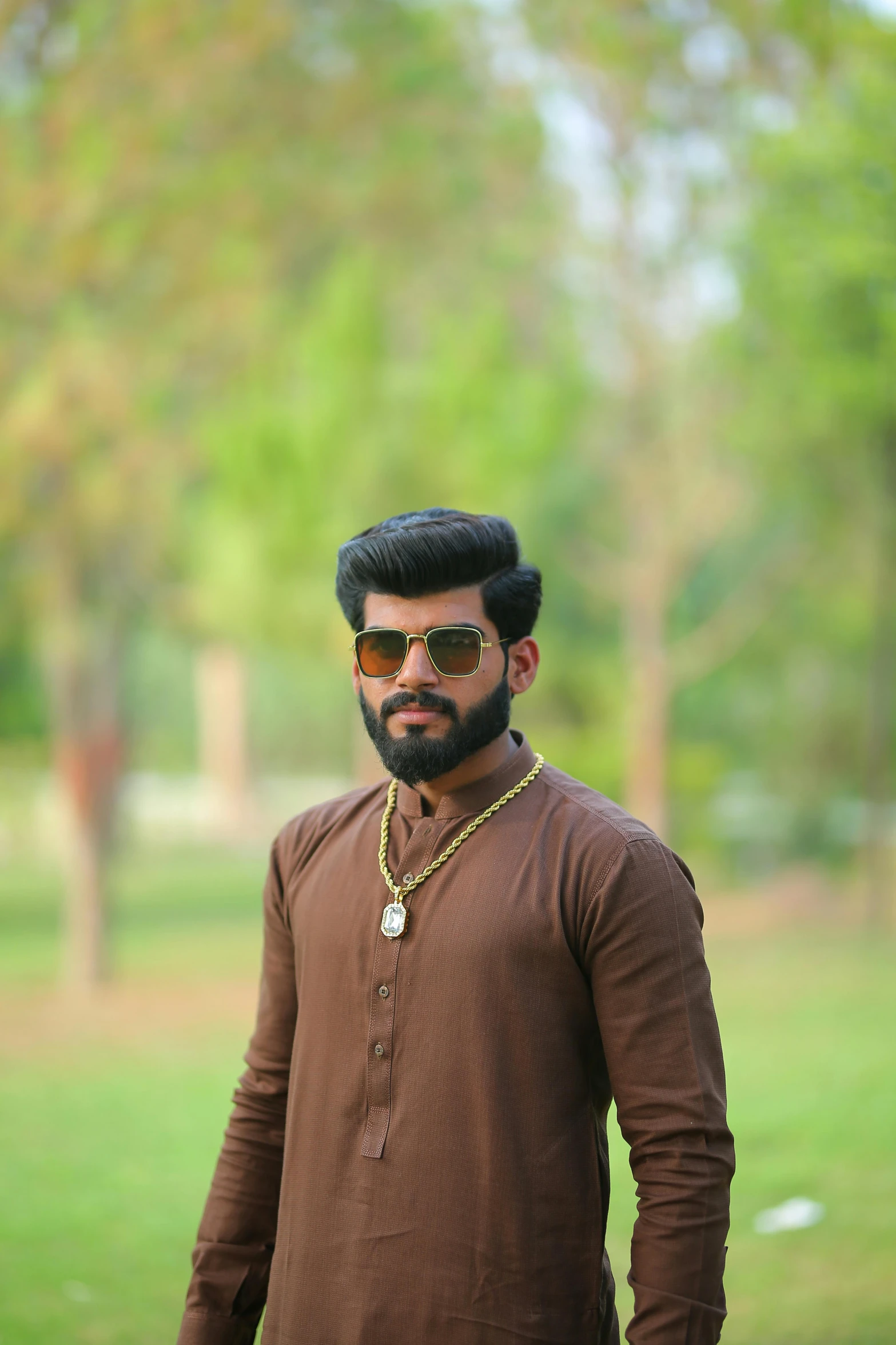 a man standing in a park wearing a brown shirt, a picture, hurufiyya, profile image, trending photo, profile picture 1024px, single subject