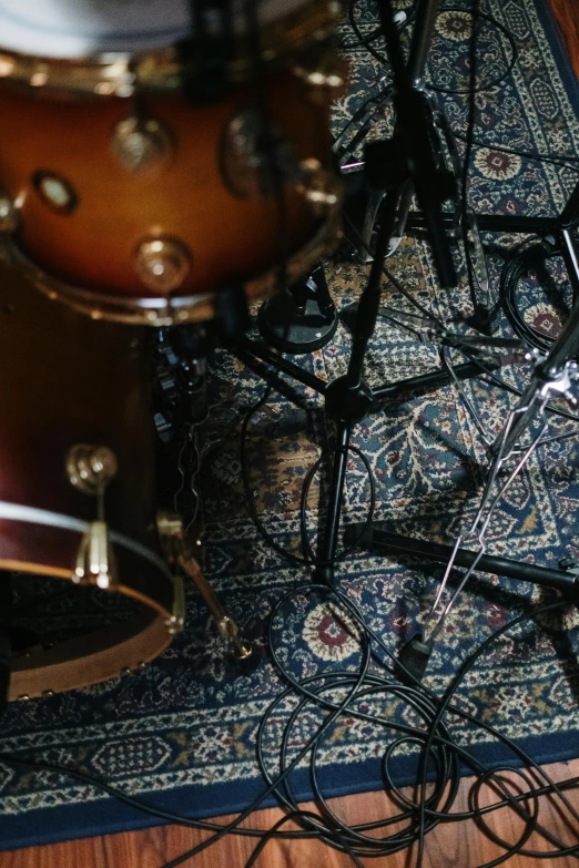 a pair of drums sitting on top of a wooden floor, carpet at the floor, looking down on the camera, up close, studio lightning