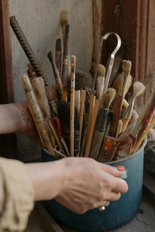 a person holding a bucket full of baseball bats, an oil painting, inspired by artist, trending on unsplash, process art, serge marshennikov, chinese ink brush, where a large, crafts and souvenirs