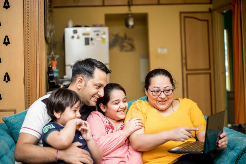 a family sitting on a couch looking at a laptop, a portrait, pexels contest winner, hurufiyya, avatar image, chilean, maintenance photo, full frame image