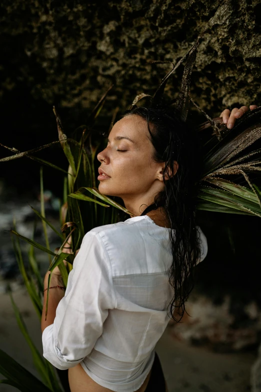 a woman standing on top of a beach next to a tree, a picture, unsplash, renaissance, soaking wet hair, wearing a white shirt, zoë kravitz, close up portrait photo