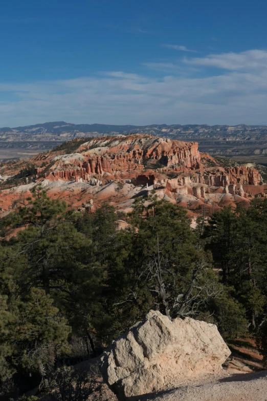 a man standing on top of a mountain next to a large rock, red sandstone natural sculptures, gigapixel, bryce 3 d, 4k photo gigapixel