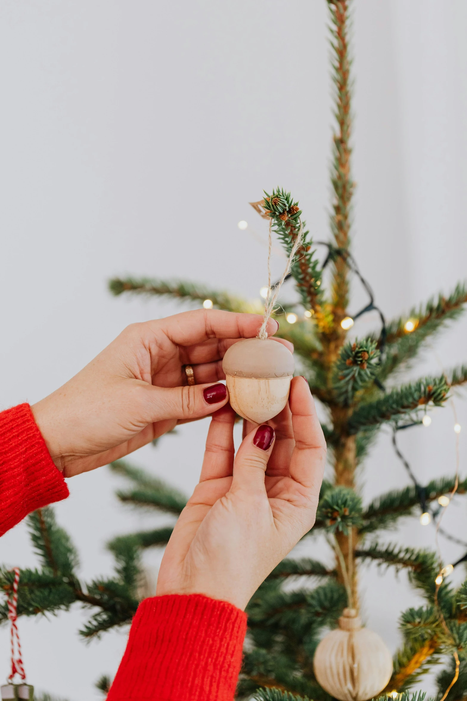 a woman decorating a christmas tree with ornaments, trending on pexels, folk art, holding a wood piece, smooth tiny details, scandinavian, sparse detail