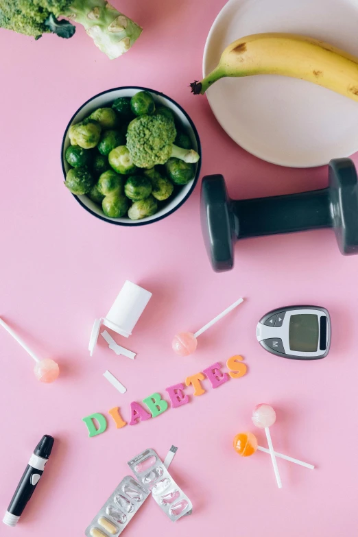 a pink table topped with a bowl of fruit and vegetables, lifting weights, drugs, green letters, flatlay