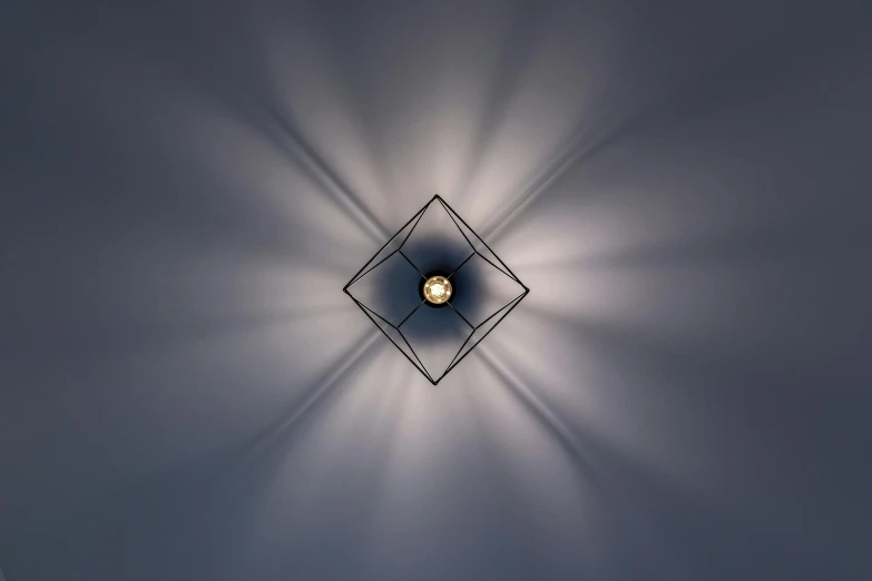 a close up of a light on a wall, deviantart, bauhaus, star inside, square black pupil centered, featuring rhodium wires, dynamic volumetric lighting