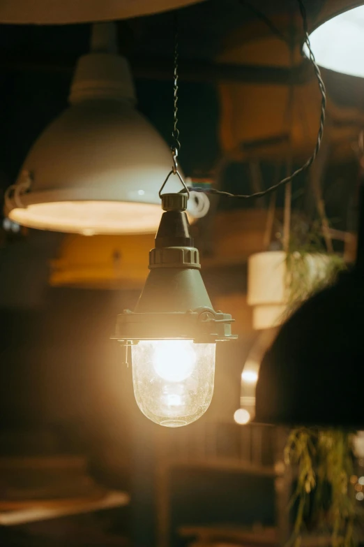 a couple of lights hanging from a ceiling, a portrait, by Jessie Algie, unsplash, soft vintage glow, lamp ( ( ( fish tank ) ) ) ), industrial lighting, beautifully soft lit
