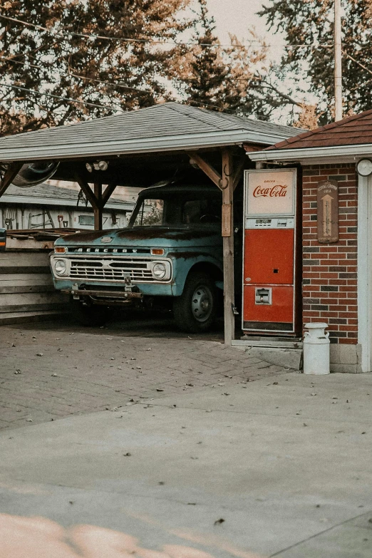 an old truck parked in front of a building, pexels contest winner, car garage, inside a gas station, neighborhood themed, 1970's