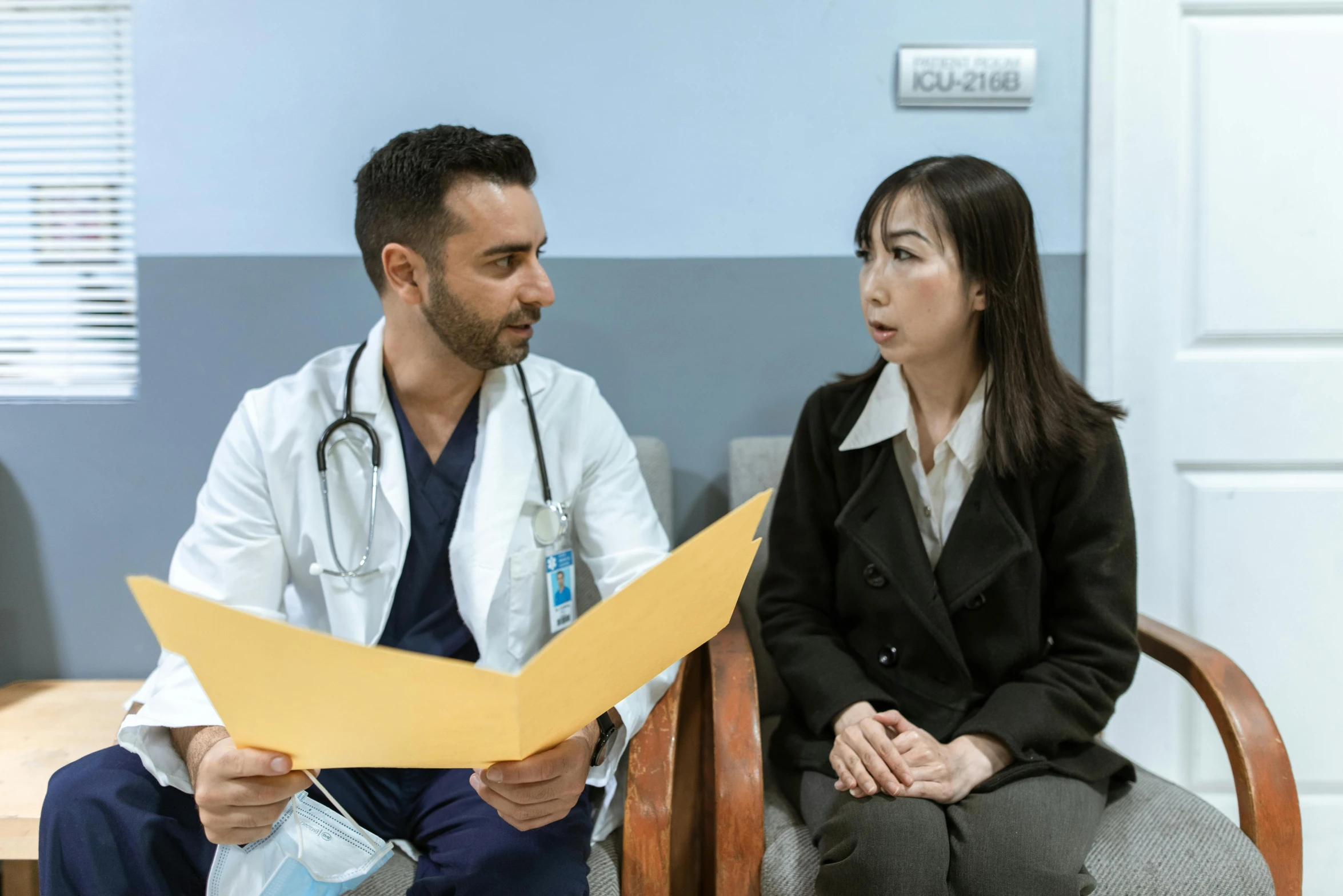 a man and a woman in a doctor's office, a colorized photo, pexels contest winner, hurufiyya, asian female, background image, convincing, opening scene