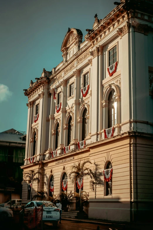 a large white building sitting on the side of a road, inspired by Mihály Munkácsy, pexels contest winner, quito school, red white and gold color scheme, war theatre, são paulo, profile image