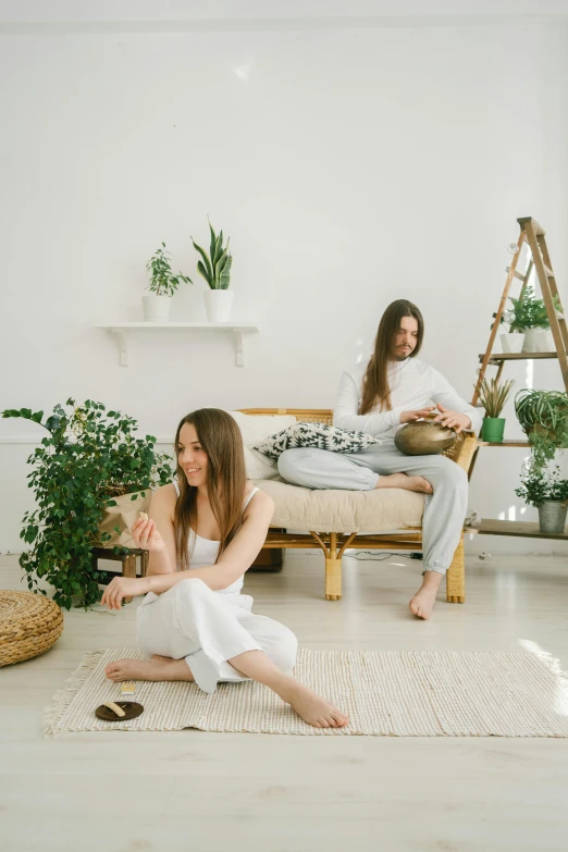 two women sitting on a couch in a living room, pexels contest winner, aestheticism, plants allover, white studio background, man and woman, anna nikonova aka newmilky