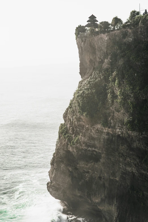 a man standing on top of a cliff next to the ocean, by Daniel Seghers, bali, texture detail, seen from a distance, canyon