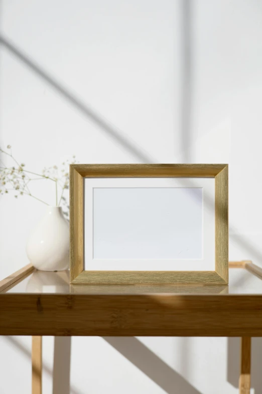 a picture frame sitting on top of a wooden table, inspired by Emil Carlsen, unsplash, shades of gold display naturally, bright daylight indoor photo, 3/4 front view, product image