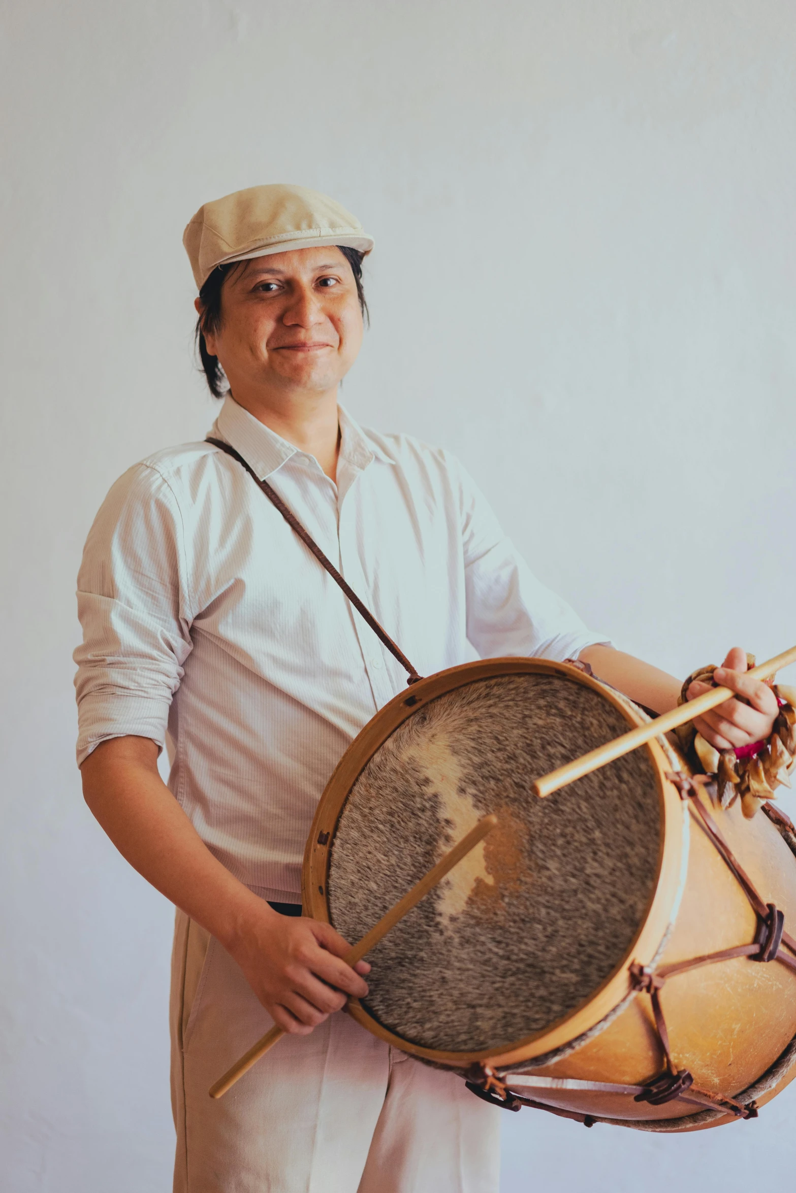 a man in a white shirt holding a drum, inspired by Agustín Fernández, headshot, peruvian looking, brown, taken in the early 2020s