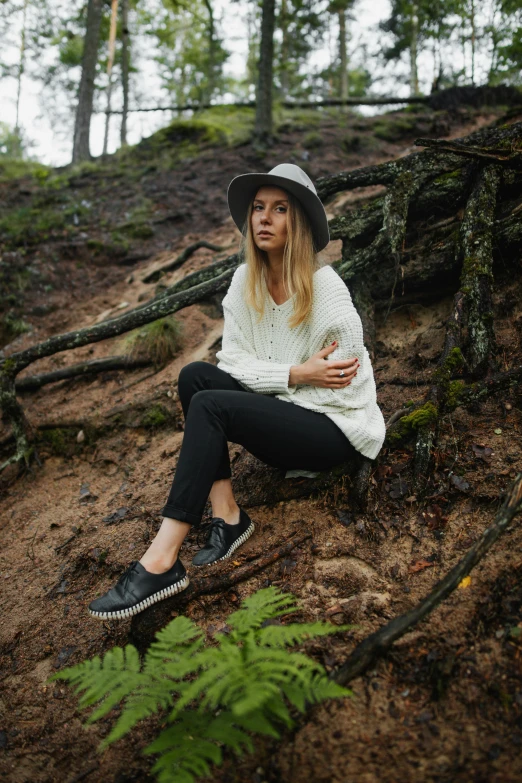 a woman sitting on the ground in the woods, black loafers, avatar image, audeze, wearing casual sweater